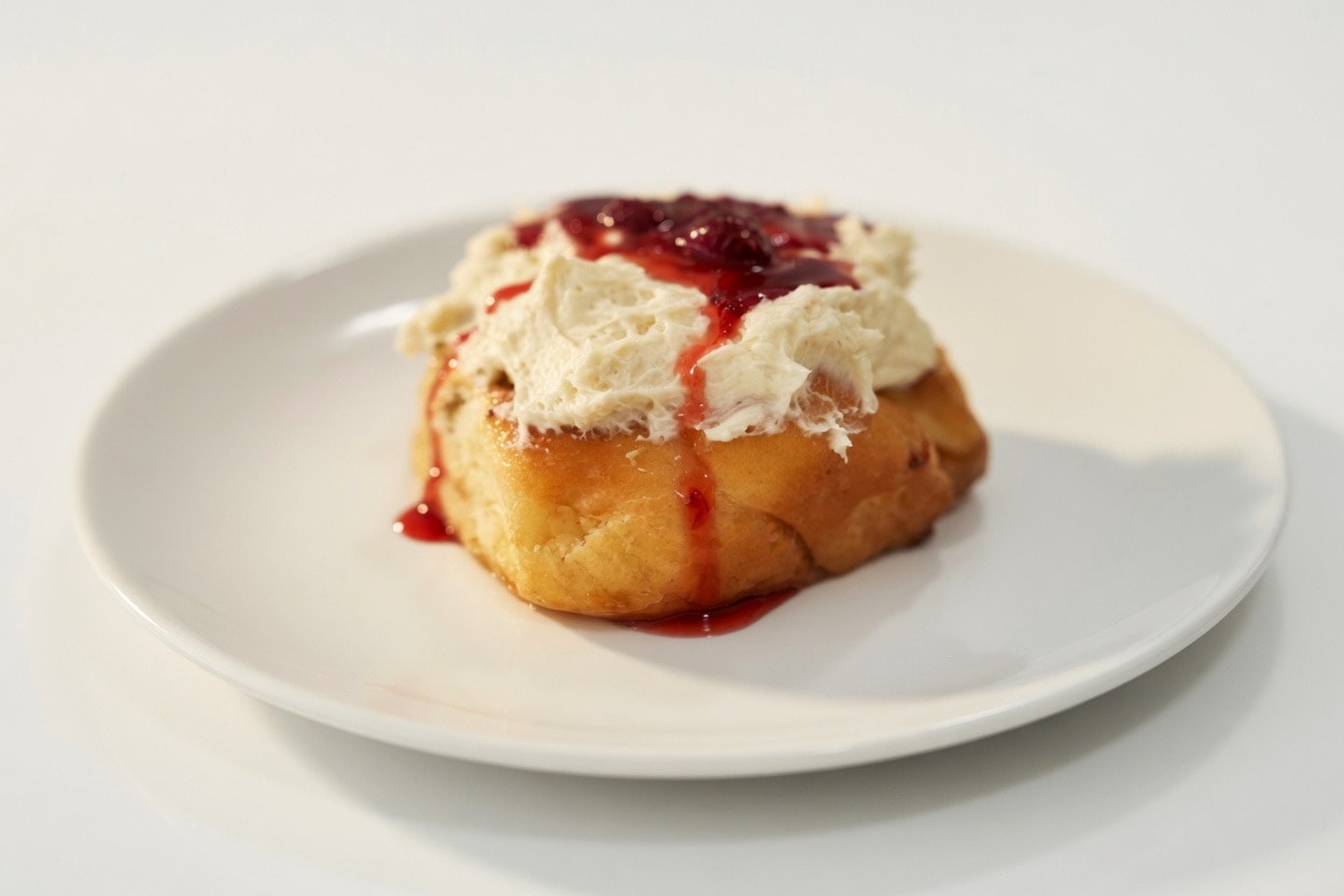 Strawberry cinnamon roll with cream cheese frosting and jam